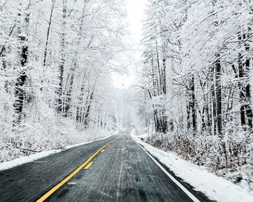 What should I do if I am caught by snow during a motorcycle route?
